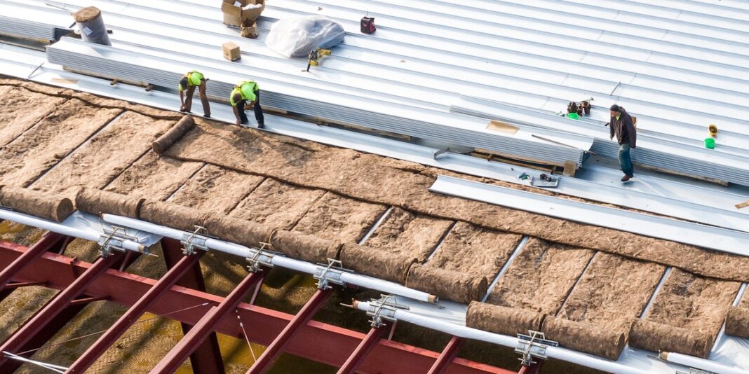 Constructionworkersinstallinginsulationandroofpanels_USA_shutterstock_1929213377.jpg